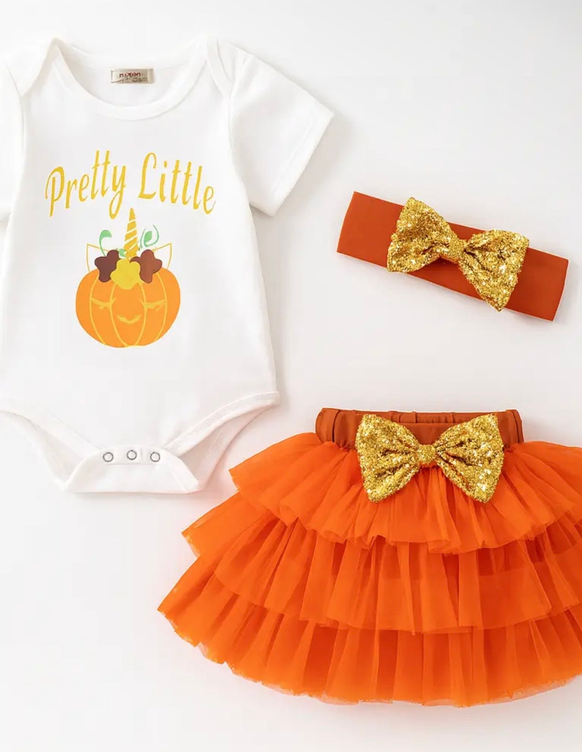 Baby girl pumpkin outfit with white bodysuit, orange layered tutu skirt, gold bows, and matching headband